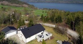 Øverskogen/Lier – Pen, innholdsrik enebolig over 2 plan med nyere dobbelgarasje, stor terrasse og grillhus. Solrik beliggenhet med fantastisk fjordutsikt. Boligen ligger i naturskjønne omgivelser men samtidig kort vei til Sandvika over Sollihøgda!